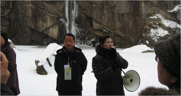 A South Korean tourist, left, and a North Korean guide at Pakyon Falls, the first stop on a tour.