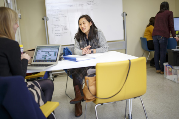 Priscilla Chan, center, CEO of The Primary School in East Palo Alto, is pictured in consultation with an unidentified staff member. Chan, the wife of Facebook co-founder and CEO Mark Zuckerberg, founded The Primary School as a way to try to combat and alleviate the effects of poverty on children. (Courtesy of Priscilla Chan)